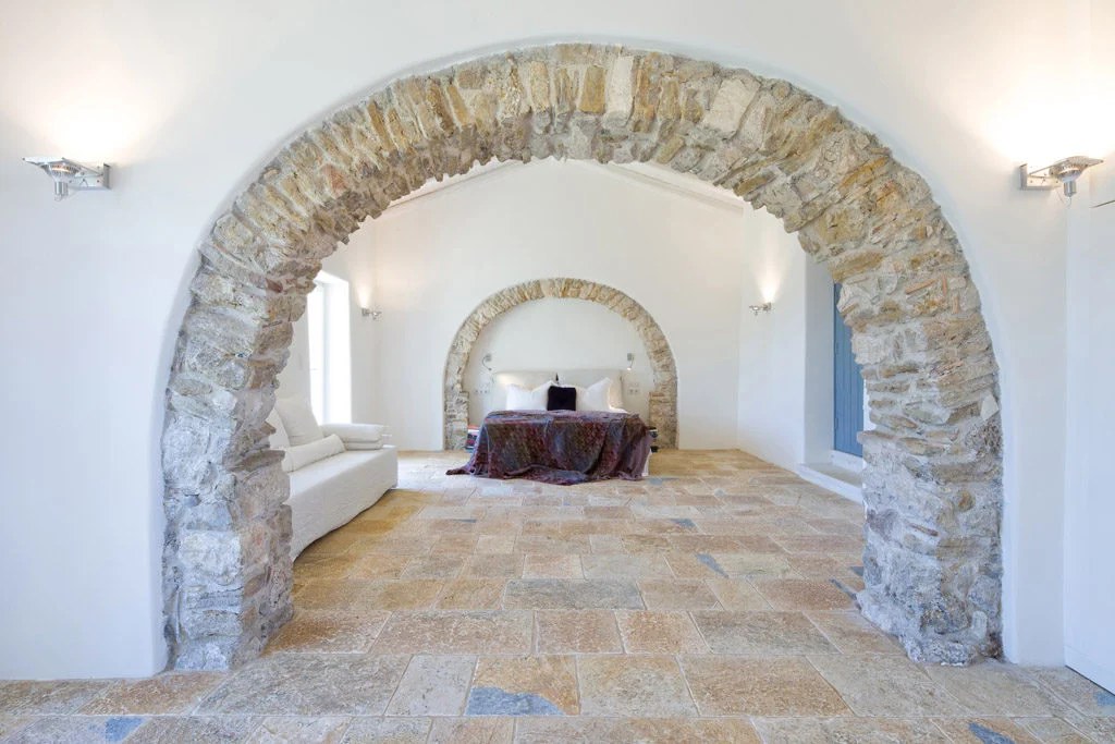 Stone archway in bedroom with white walls