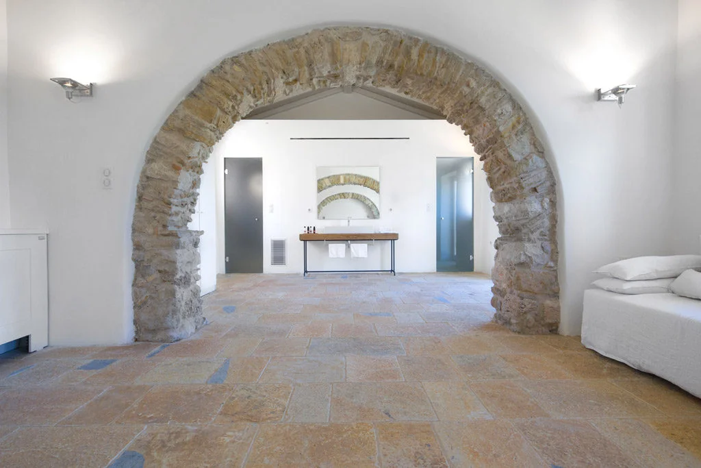 Stone archway in bedroom with white walls