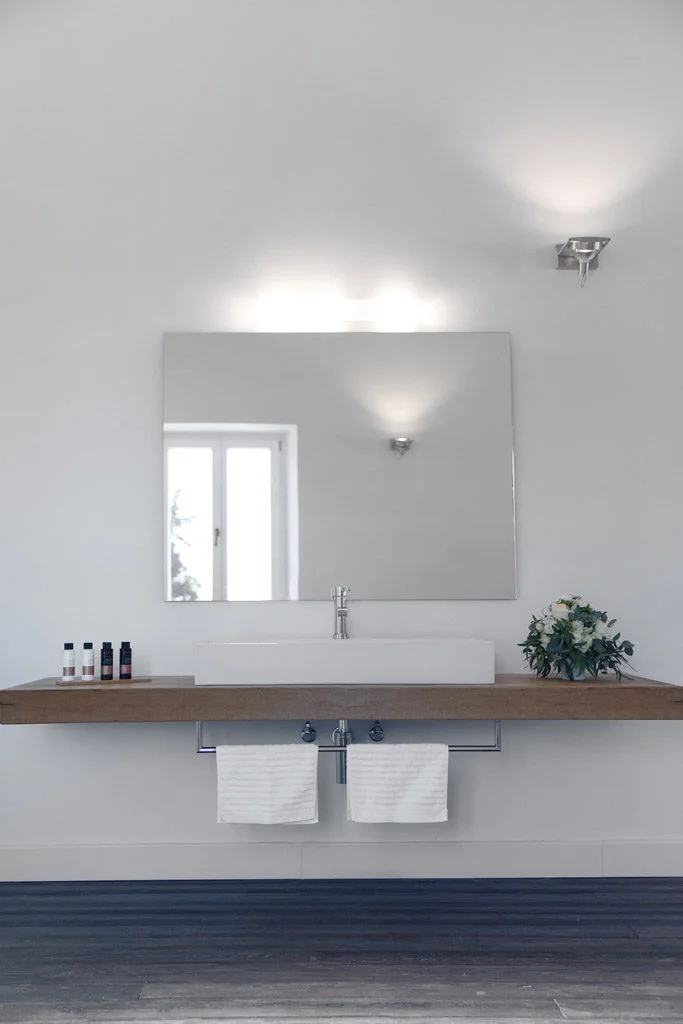 Large sink with chrome features a large mirror on wall