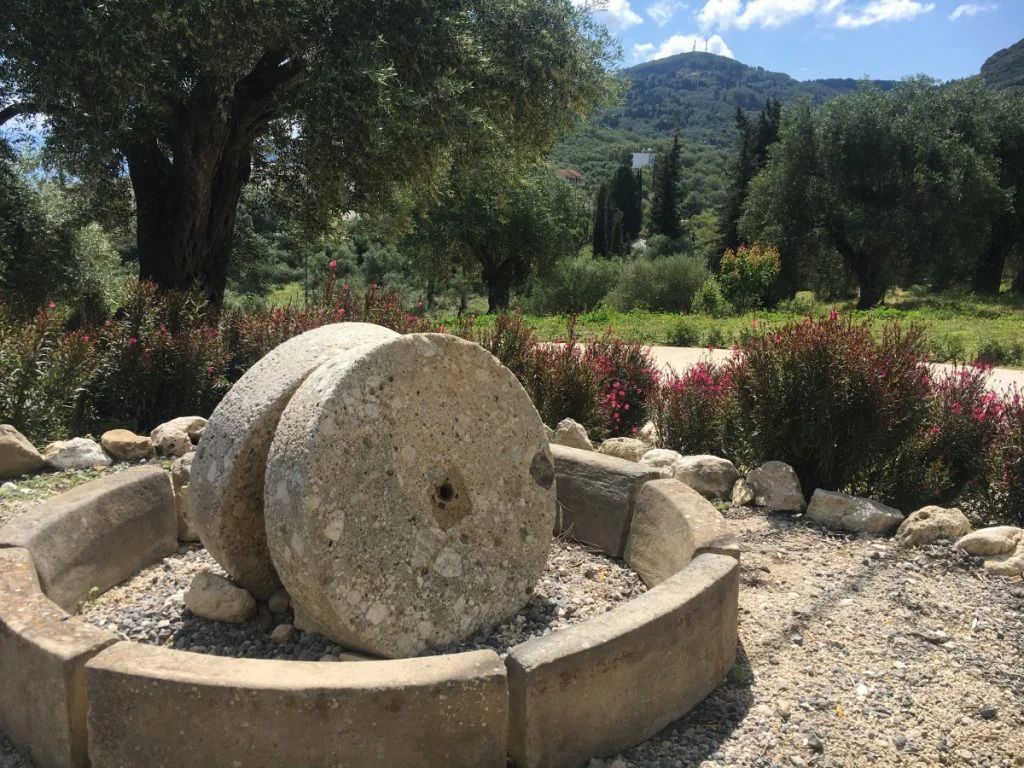 Stone wheels from an old mill in the garden with an mountain backdrop
