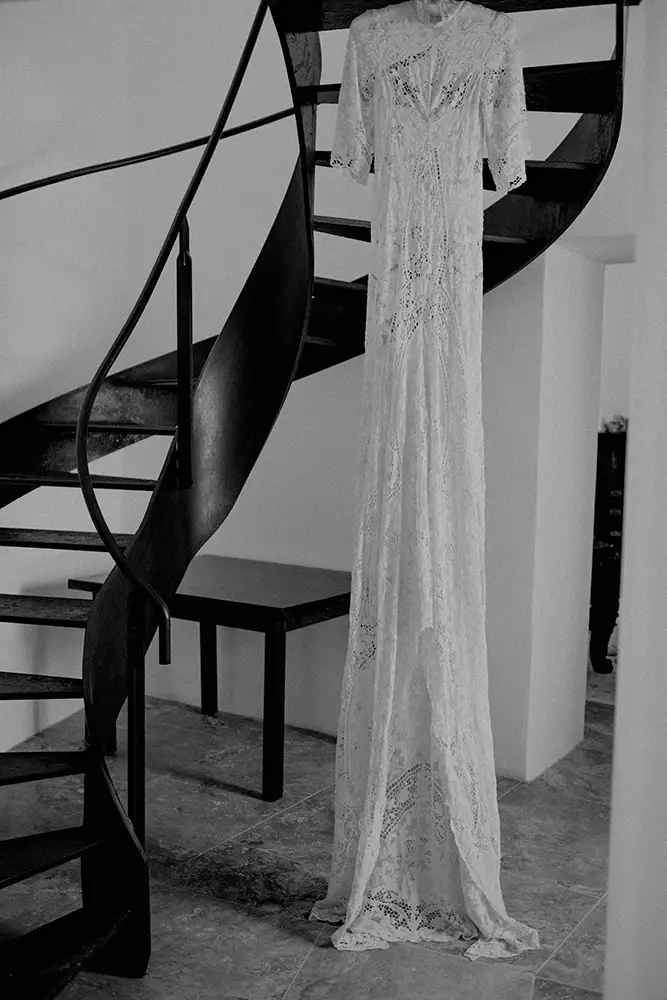 Wedding dress hanging up on spiral stair case.
