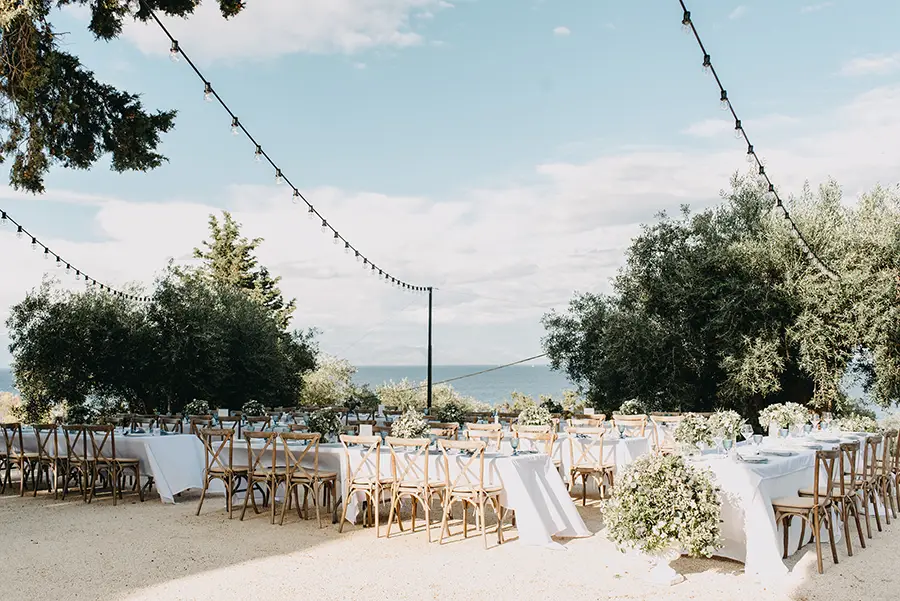 Outdoor wedding seating with string lights with sea views in the background