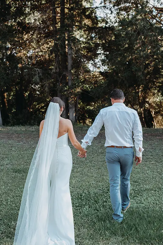 Bride and groom holding hands walking away