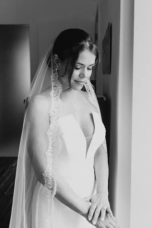 Bride ready in room looking down at her hands
