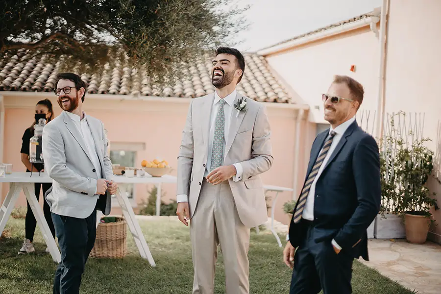 Groom with two guests laughing in the garden